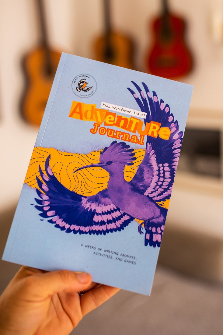 A child holding the Worldwide Adventure Journal