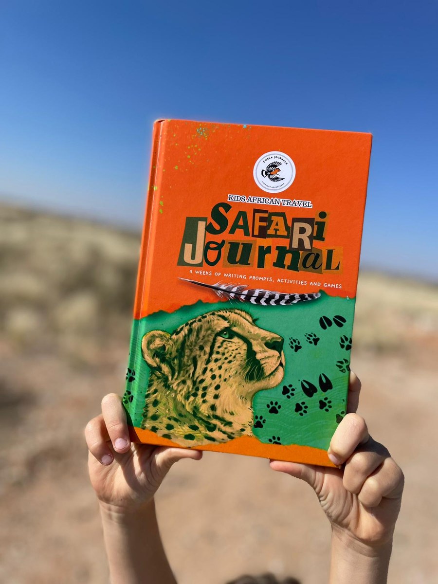 A child holding up the African Safari Journal in the bush