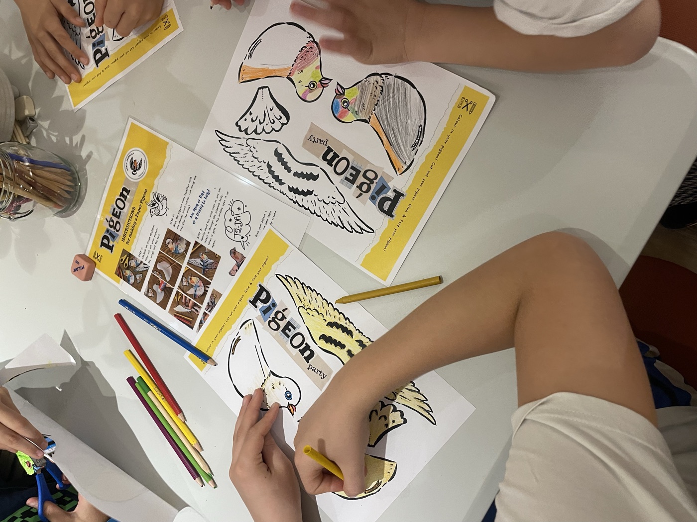Kids colouring their paper pigeons at the Feathered Friends workshop