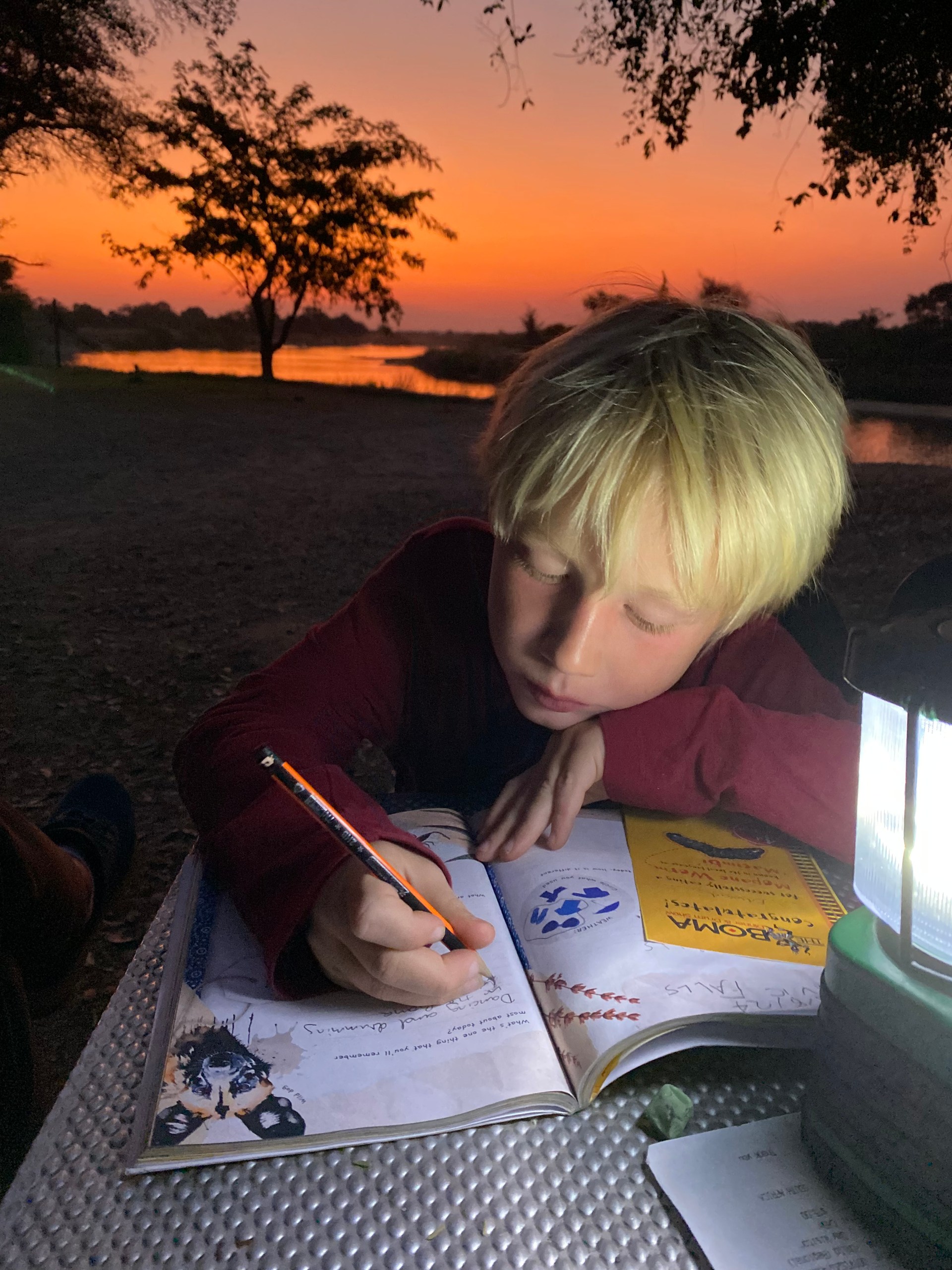 Child writing in a Zwela South African travel journal